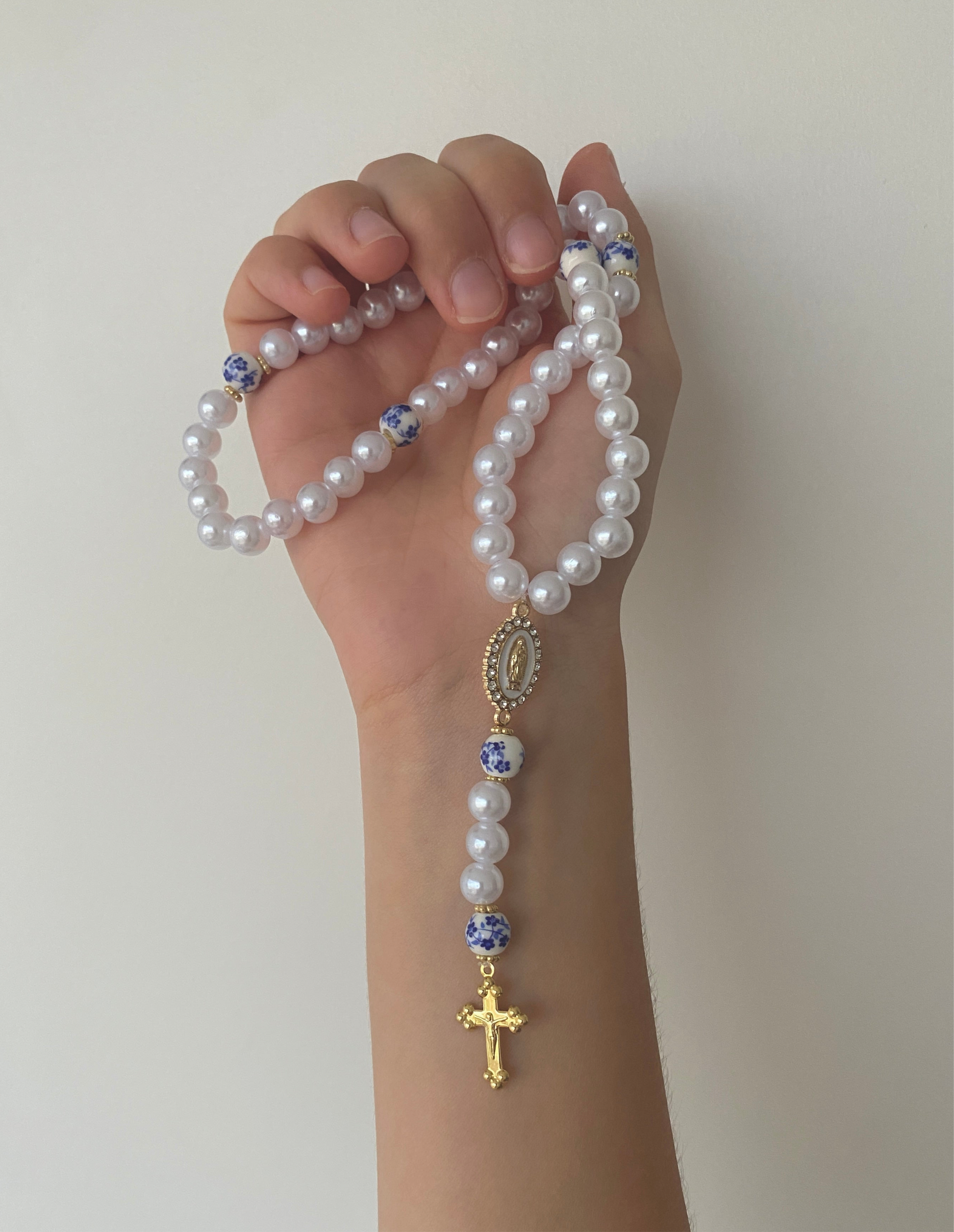 Chapelet chrétien artisanal blanc et bleu azur avec une croix dorée, fabriqué à la main.