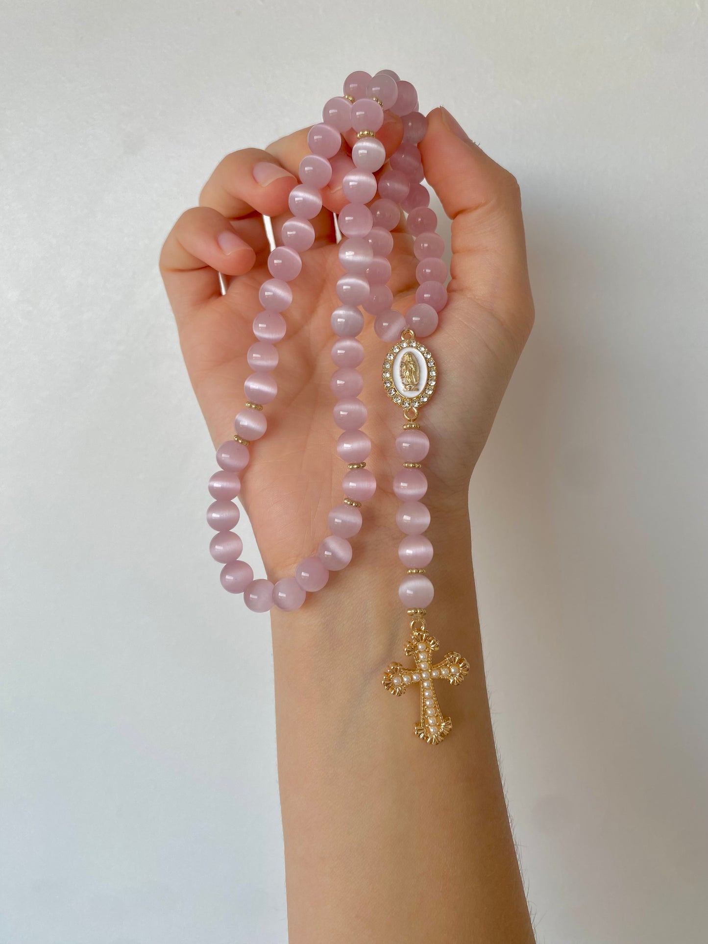 Chapelet artisanal en pierre rose avec croix dorée, fabriqué à la main.